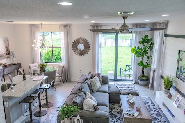 kitchen and living room with gray counters and couch and a ceiling fan 